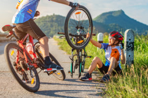 Cyclists on the side of a road changing a tire