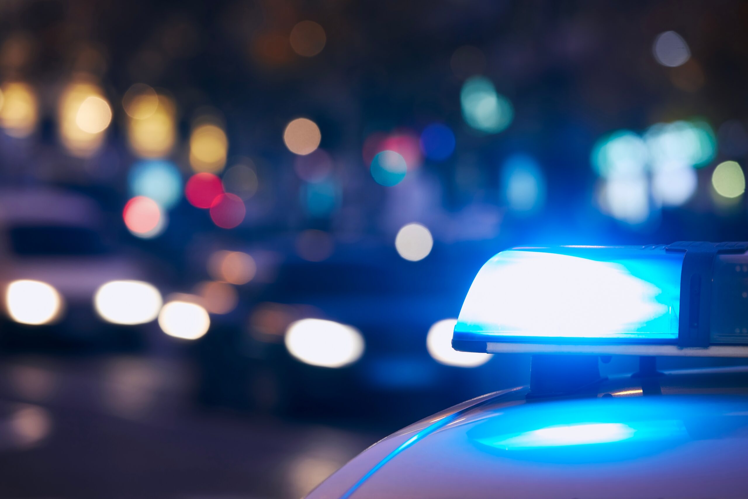 Emergency services vehicle with blue lights in a city setting, representing frontline professionals supported by Temple Legal Protection’s insurance products.