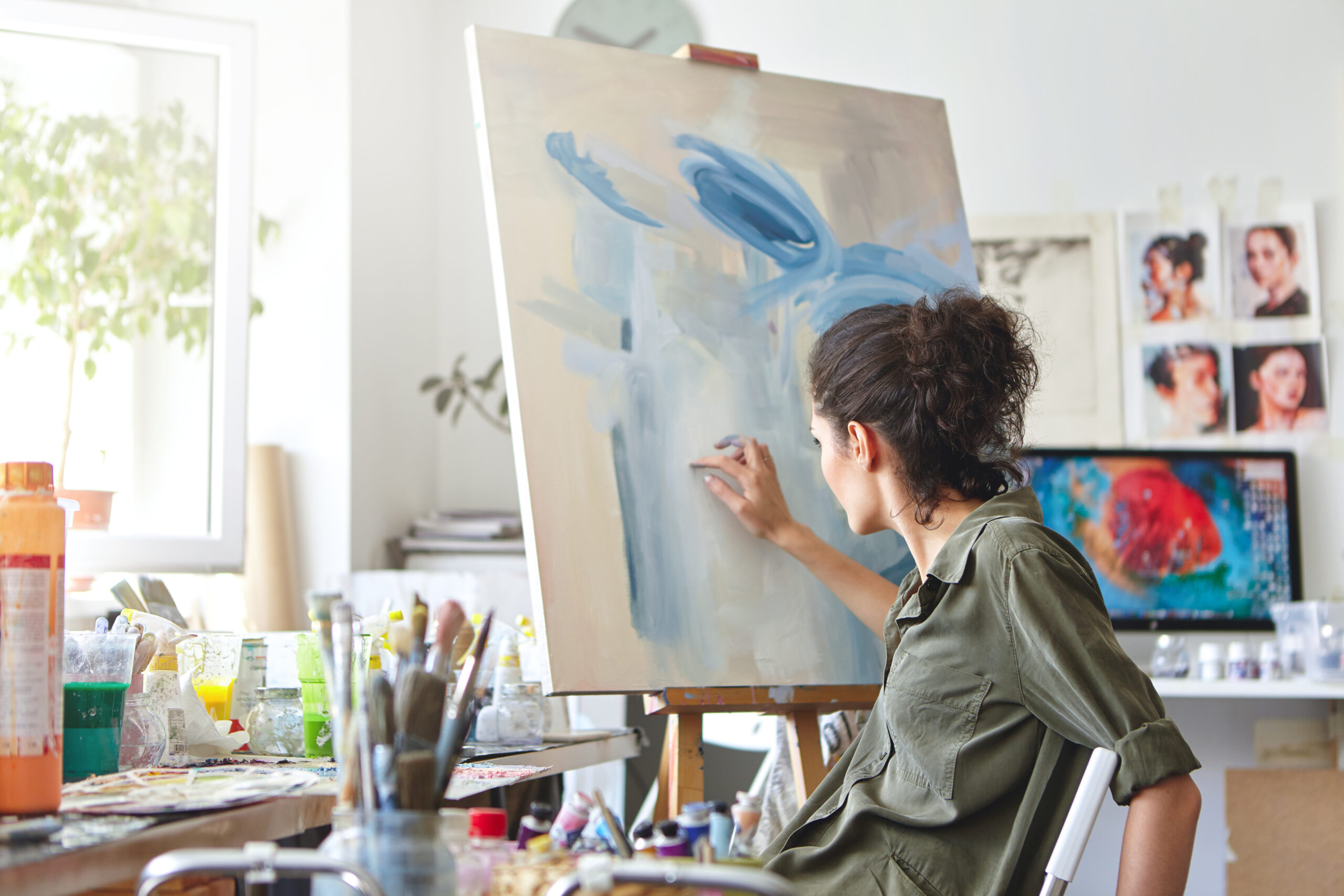 Person painting on a canvas in a home studio, representing hobbies and creative activities supported by Temple Legal Protection’s legal expenses insurance for niche groups
